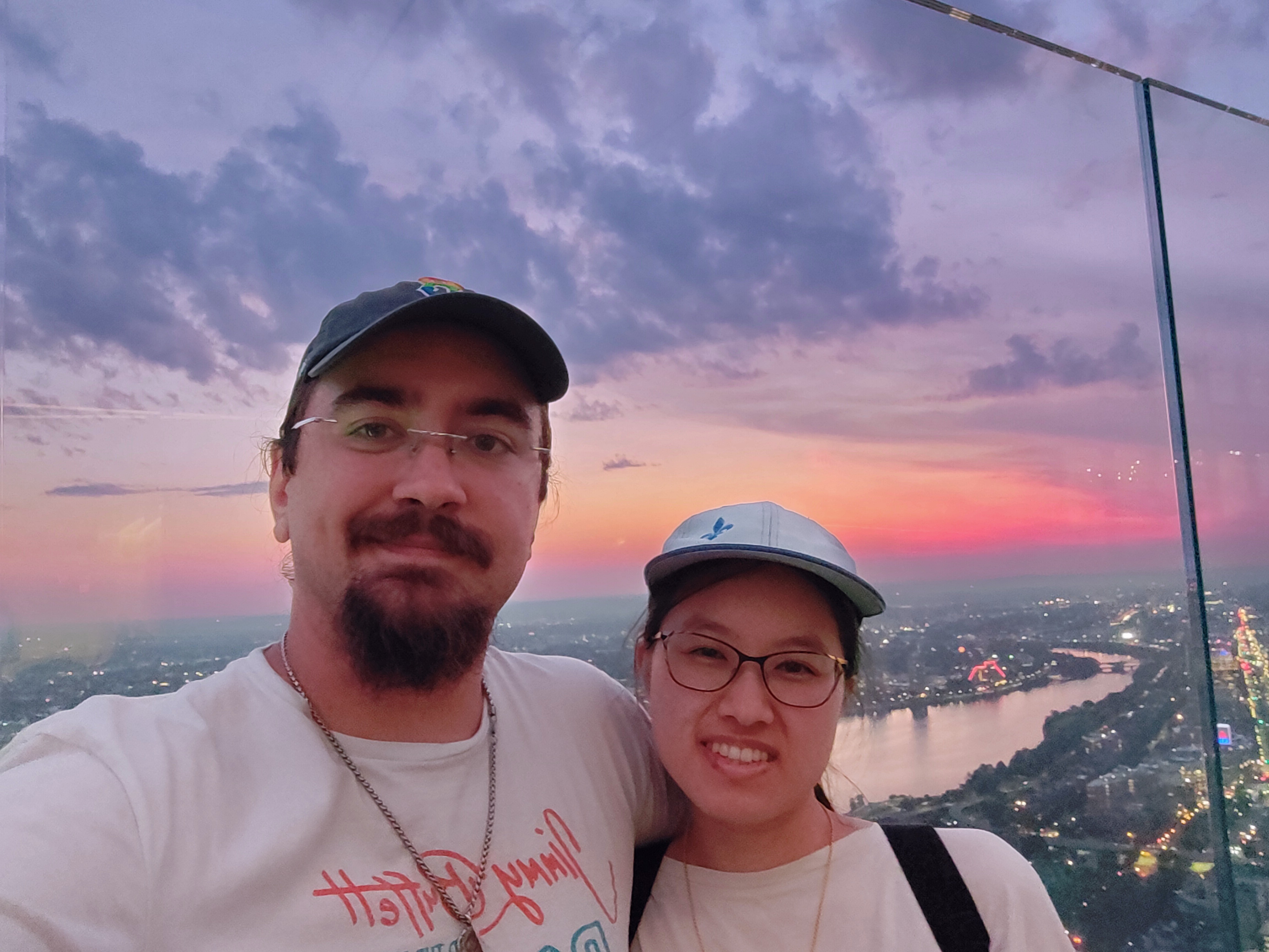 Megan and Andrew atop the Prudential Tower overlooking a sunset over the Charles River.